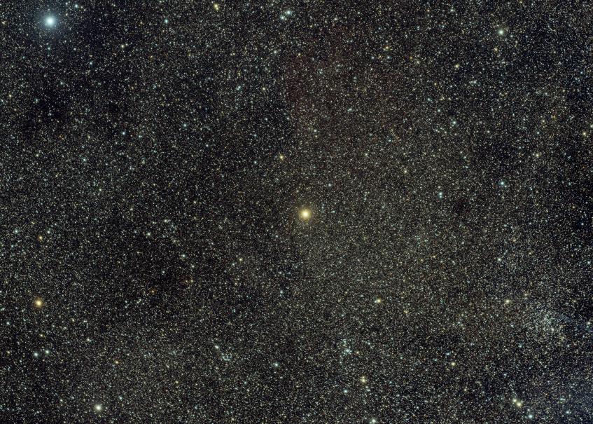 A bright orange star on a background that is dense with faint stars.