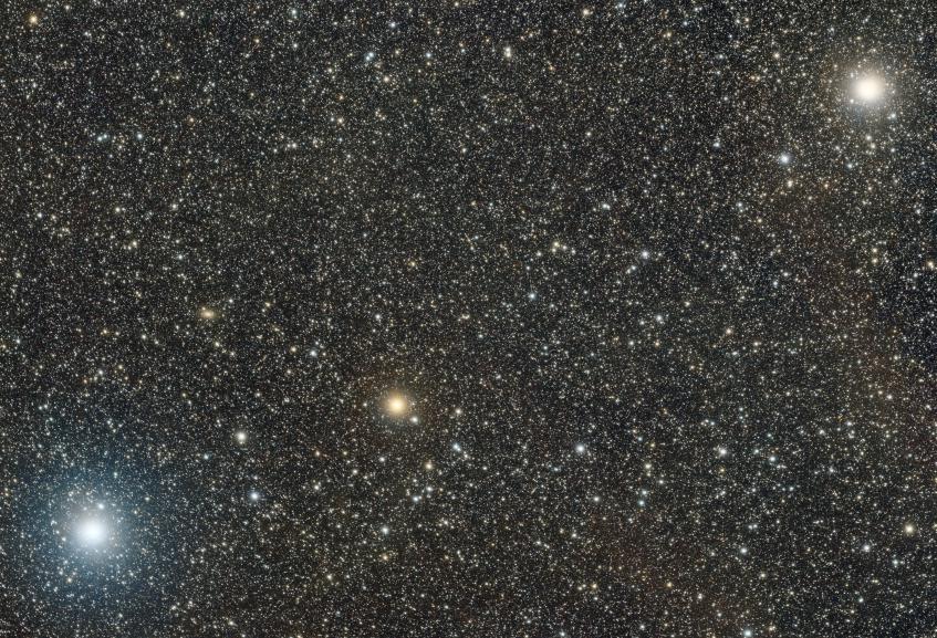 A bright orange star flanked by two even brighter white stars.